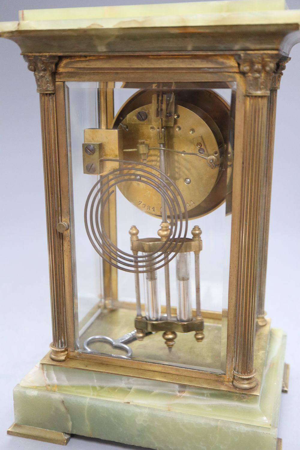 A four glass onyx and brass Corinthian columned clock, height 50cm width 19cm